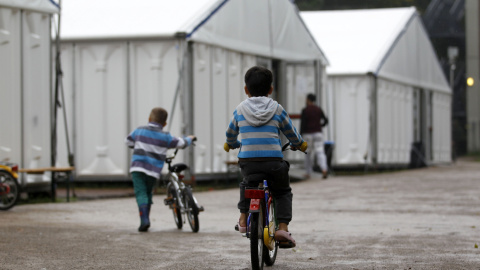 Niños montan en sus bicis en un campo de refugiados temporal en Düsseldorf, Alemania. REUTERS/Ina Fassbender