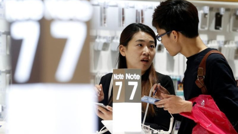 Una pareja examina un Galaxy Note 7 en la sede de Samsung  en Seúl. REUTERS/Kim Hong-Ji