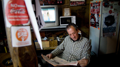 Un trabajador de Coca-Cola en Fuenlabrada lee el periódico en el interior de campamento donde llevan un año exigiendo la reapertura de la fábrica. -JAIRO VARGAS