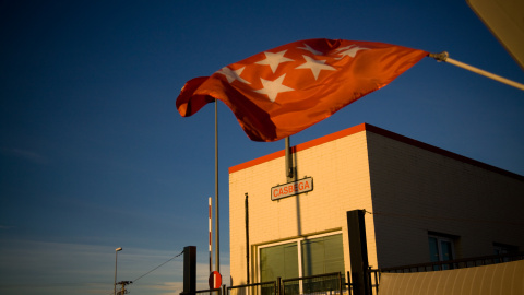 Una bandera de la comunidad de Madrid ondea ante la plata de Coca-Cola en Fuenlabrada, donde los trabajadores llevan un año acampados contra su cierre. -JAIRO VARGAS