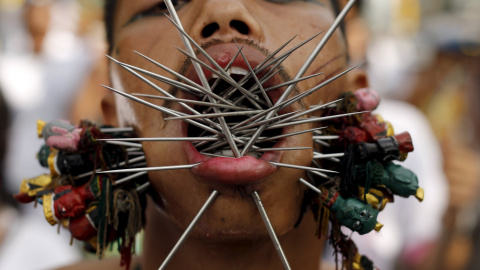 Un devoto del santuario chino Samkong  camina con agujas que le atraviesan las mejillas durante una procesión que celebra el festival anual vegetariano en Phuket, Tailandia, 16 de octubre de 2015. REUTERS / Jorge Silva