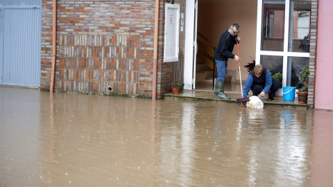 Vecinos de la localidadad cantabra de Ampuero intentan que la lluvia no entre en su domicilio tras las lluvias que han desbordado el rio Ason a su paso por el pueblo. EFE/Pedro Puente Hoyos