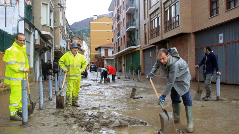 Vecinos de la localidad de Sodupe limpian las calles de tras las inundaciones del rio Herrerías a su paso por esta localidad que ha causado destrozos en viviendas y negocios. EFE/Luis Tejido