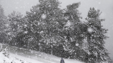 Una persona camina en medio de una fuerte nevada por el alto de San Cristobal (861 m), en las cercanias de Pamplona. EFE/Jesús Diges