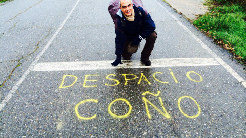 Susaeta posando en una carretera señalando una pintada en la que se lee 'Despacio coño'. Susaeta posando en una carretera señalando una pintada en la que se lee 'Despacio coño'.