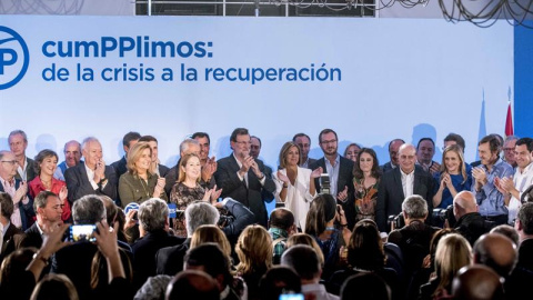 Rajoy (c), rodeado por los miembros de su Gobierno, recibe los aplausos de los asistentes al acto "CumPPlimos: De la crisis a la recuperación", en el que ha hecho hoy balance de su gestión, tras una semana convulsa para los populares, marca