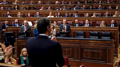 El candidato a la Presidencia del Gobierno, Pedro Sánchez (de espaldas) observa la bancada del PP y Vox tras finalizar su discurso en el Congreso de los Diputados durante la primera jornada de la sesión de su investidura como presidente del