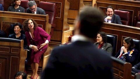 La ministra de Hacienda en funciones, María Jesús Montero (2i), interpela al presidente de Vox, Santiago Abascal (de espladas), durante su intervención en el Congreso de los Diputados en la primera jornada de la sesión de investidura de Ped