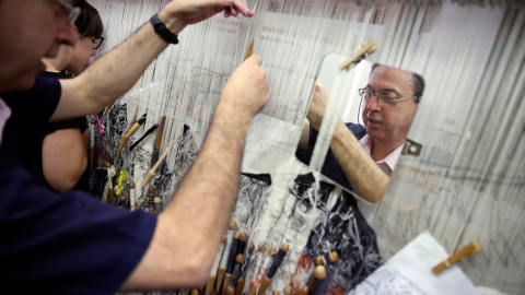 José Antonio Carbajal, empleado de la Real Fábrica de Tapices, teje en un telar de siglos de antigüedad. REUTERS / Susana Vera