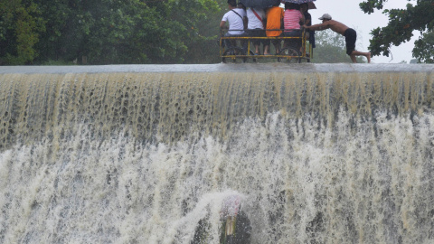 Residentes cruzan una presa, debido al aumento del agua provocado por el tifón Koppu, en la ciudad de Las Pinas, Manila. REUTERS/Esdras Acayan
