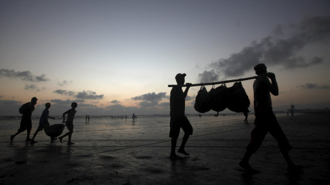 Pescadores llevan su pesca del día pasando por la playa Clifton, en su camino a casa, en Karachi, Pakistán, 19 de octubre de 2015. REUTERS / Athar Hussain