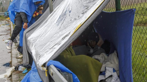 Varios refugiados se protegen de la lluvia mientras esperan en el punto fronterizo de Trnovec, Croacia./ EFE Varios refugiados se protegen de la lluvia mientras esperan en el punto fronterizo de Trnovec, Croacia./ EFE
