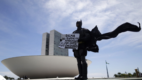 Un hombre, vestido de Batman, delante del parlamento brasileño en Brasilia, protesta contra la corrupción, a raíz del escándalo de los supuestos pagos de Petrobrás al PT. El manifestante sostiene una pancarta que dice: " Dilma, tu tiempo se