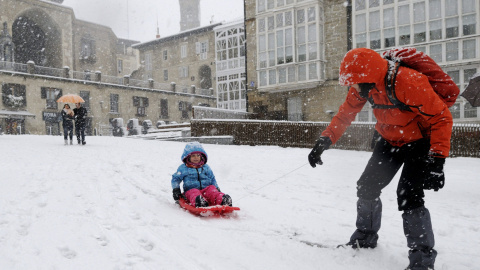 Un niño se desliza con un trineo en la Plaza de la Virgen Blanca, en Vitoria. /EFE