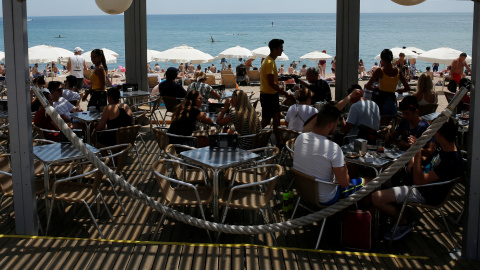 Turistas en un chiringuito en la playa de la Barceloneta, en Barcelona. REUTERS