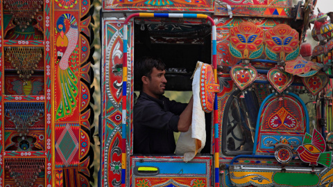 Un hombre limpia el espejo de su camión llamativamente decorado en Charsadda a las afueras de Peshawar, Pakistán. /REUTERS