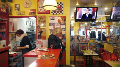 La rueda de prensa semestral del presidente frances Francois Hollande en un televisor de un bar en Paris. REUTERS/Charles Platiau
