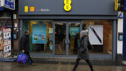 Unos peatones pasan por delante de una tienda de la operadora de telefonía móvil EE en Londres. REUTERS/Suzanne Plunkett Unos peatones pasan por delante de una tienda de la operadora de telefonía móvil EE en Londres. REUTERS/Suzanne Plunkett