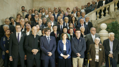 El presidente de la Generalitat Carles Puigdemont y la presidenta del Parlament de Cataluña Carme Forcadell junto a otros diputados, posan con familiares y víctimas del franquismo tras la sesión que ha acordado por unanimidad tramitar la pr