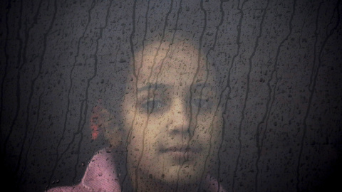 Un niña refugiada siria se sienta en un autobús en un campamento de registro temporal durante una tormenta de lluvia en la isla griega de Lesbos. REUTERS / Yannis Behrakis
