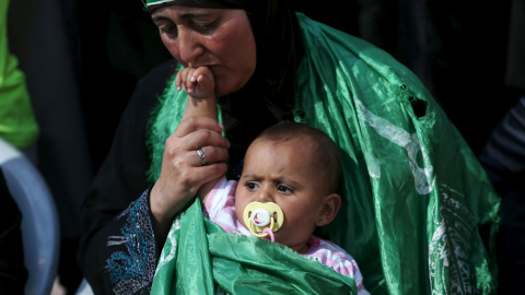 La madre del palestino Uday al-Masalma, que fue asesinado por las tropas israelíes el martes, llora mientras sostiene la hija de Uday durante su funeral cerca de la ciudad cisjordana de Hebrón 21 de octubre de 2015. REUTERS / Mohamad Torokm