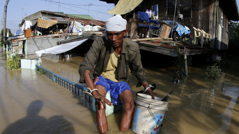 Un hombre se sienta en la verja de su casa aislada a causa de las inundaciones provocadas por el tifón Koppu en la ciudad de Calumpit, en la provincia de Bulacan, al norte de Manila (Filipinas). EFE/Francis R. Malasig