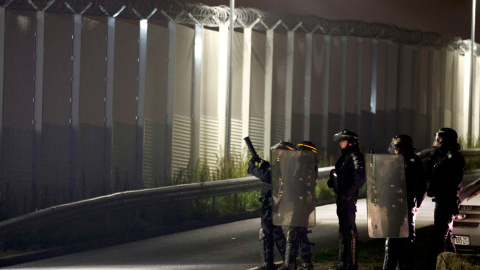 Antidisturbios franceses junto a la alambrada instalada para tratar de diasuadir a los internos en La Jungla de tratar de llegar a Gran   Bretaña en camiones en la víspera de la evacuación y desmantelamiento del campamento.- PASCAL ROSSIGNO