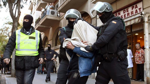 Uno de los tres detenidos por la Guardia Civil, implicados en una red de captación y envío de personas para su incorporación a la organización terrorista DAESH, sale custodiado por agentes de la benemérita en la calle Marina de Barcelona. E Uno de los tres detenidos por la Guardia Civil, implicados en una red de captación y envío de personas para su incorporación a la organización terrorista DAESH, sale custodiado por agentes de la benemérita en la calle Marina de Barcelona. E