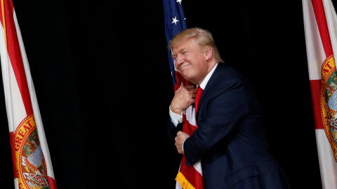 El candidato republicano a la presidencia de Estados Unidos, Donald Trump, abraza una bandera nacional durante un mítin en Tampa, Florida. REUTERS/Jonathan Ernst El candidato republicano a la presidencia de Estados Unidos, Donald Trump, abraza una bandera nacional durante un mítin en Tampa, Florida. REUTERS/Jonathan Ernst
