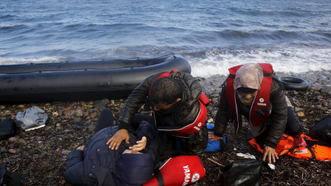 Refugiados sirios descansan agotados momentos después de desembarcar en una playa en la isla griega de Lesbos. REUTERS / Yannis Behrakis
