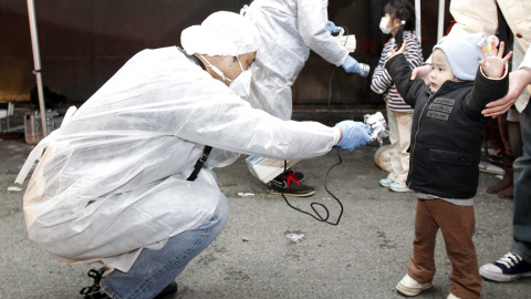 Miembros de los equipos de protección examinan a varios niños para detectar signos de la radiación en zona de la planta nuclear de Fukushima (13 de marzo de2011). REUTERS / Kim Kyung-Hoon