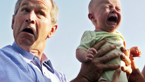 El presidente estadounidense, George W. Bush sostiene un bebé llorando a su llegada para una cena al aire libre con la canciller alemana, Angela Merkel, en Trinwillershagen, Alemania (13 de julio de  2006). REUTERS / Jim Bourg