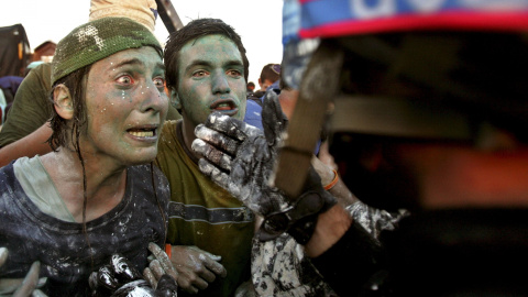 Colonos israelíes que se oponen a su  retirada de Gaza hablan con los policías encargados de vigilar la evacuación (18 de agosto de 2005). REUTERS / Nir Elias