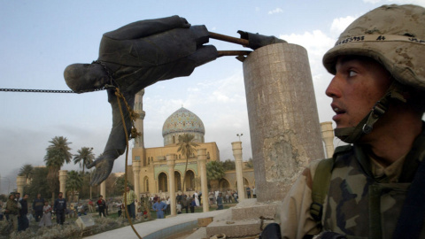 El marine Kirk Dalrymple junto a la estatua caida del presidente iraquí Saddam Hussein en el centro de Bagdad  (9 de abril de 2003). REUTERS / Goran Tomasevic