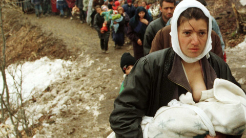 Una mujer de etnia albanesa alimenta a su bebé mientras a ella y acotros 2.000 refugiados, los desplazados por la guerra de Kosovo, se les permite entrar Macedonia (30 de marzo de 1999). REUTERS / Damir Sagolj