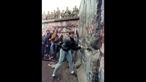 Un alemán golpea con un mazo el Muro de Berlín, bajo la mirada de los guardias de frontera del lado oriental de la ciudad (11 de noviembre de 1989). REUTERS / David Brauchli