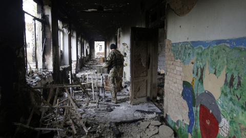 Un soldado ucraniano camina en una escuela destruida en el pueblo de Pisky cerca de Donetsk . AFP/ Anatolii STEPANOV
