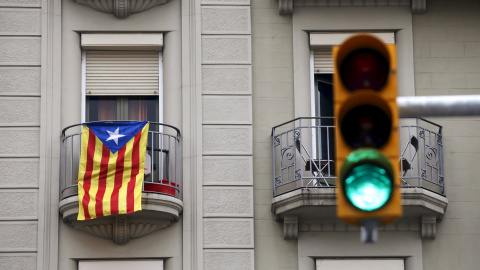 Una estelada catalana cuelga de un balcón en Barcelona al lado de un semáforo en verde. REUTERS/Albert Gea