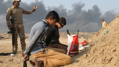 Un soldado iraquí junto a dos detenidos acusados de pertenecer al Estado Islámico, en un puesto de control en la localidad de Qayyara, al sur de Mosul. REUTERS/Goran Tomasevic Un soldado iraquí junto a dos detenidos acusados de pertenecer al Estado Islámico, en un puesto de control en la localidad de Qayyara, al sur de Mosul. REUTERS/Goran Tomasevic