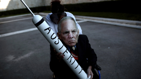 Un manifestante con una máscara del ministro alemán de finanzas, Wolfgang Schaeuble, durante una protesta anti-austeridad frente al Parlamento griego en Atenas. /ANGELOS TZORTZINIS (AFP)
