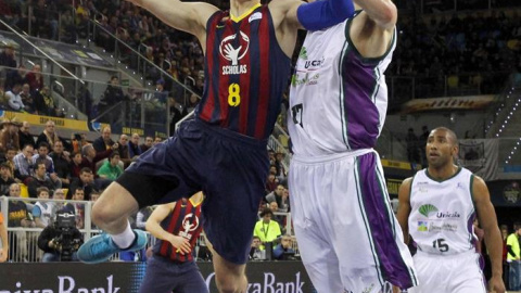 El azulgrana Mario Hezonja entra a canasta ante el pivot del Unicaja Fran Vázquez. / EFE