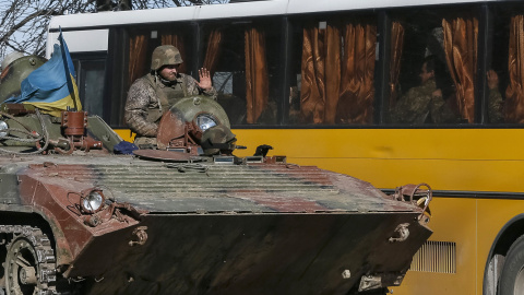 Miembro de las fuerzas armadas ucranianas da la bienvenida a sus compañeros sentados en el autobús, que se preparan para la vuelta a casa, en Artemivsk, este de Ucrania./REUTERS-Gleb Garanich