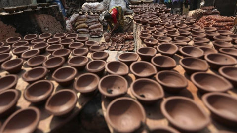 Una mujer prepara lamparillas de barro para la próxima celebración del festival Diwali en Bombay (India). EFE/Divyakant Solanki