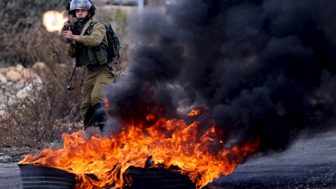 Un soldado israelí disparacontra los manifestantes palestinos durante enfrentamientos cerca del asentamiento judío de Bet El, cerca de la ciudad cisjordana de Ramala.- REUTERS / Mohamad Torokman