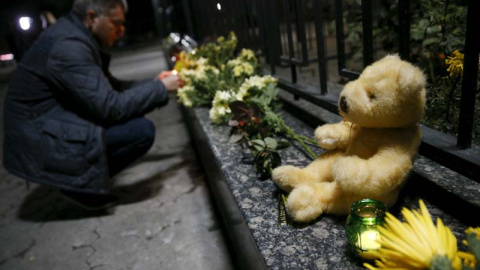 Solidaridad con las víctimas. Un hombre enciende una vela en memoria de las víctimas delante de la embajada de Rusia en Kiev. /  REUTERS (Valentyn Ogirenko)