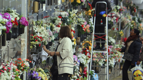 Varias personas limpian y adornan con flores las tumbas de familiares y allegados en el cementerio de Ponferrada, para la celebración del Día de Difuntos que tiene lugar mañana, día 1 de noviembre. EFE/Ana F. Barredo