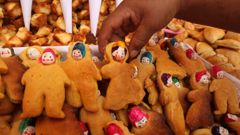 Una mujer vende "t'ant'awawas", panes antropomórficos que llevan una cara hecha de cerámica que representa a un muerto, con motivo de la celebración del Día de los Muertos, en la plaza San Francisco de La Paz (Bolivia). EFE/Martín Alipaz