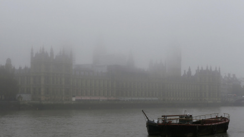 Un barco está amarrado en frente de la torre del reloj Big Ben y las Casas del Parlamento.- REUTERS.