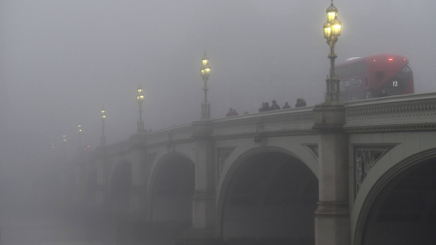 Trabajadores cruzan el puente de Westminster en una mañana brumosa en Londres.- REUTERS