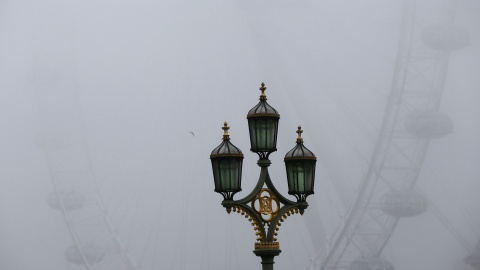 Una farola entre la niebla.- REUTERS.